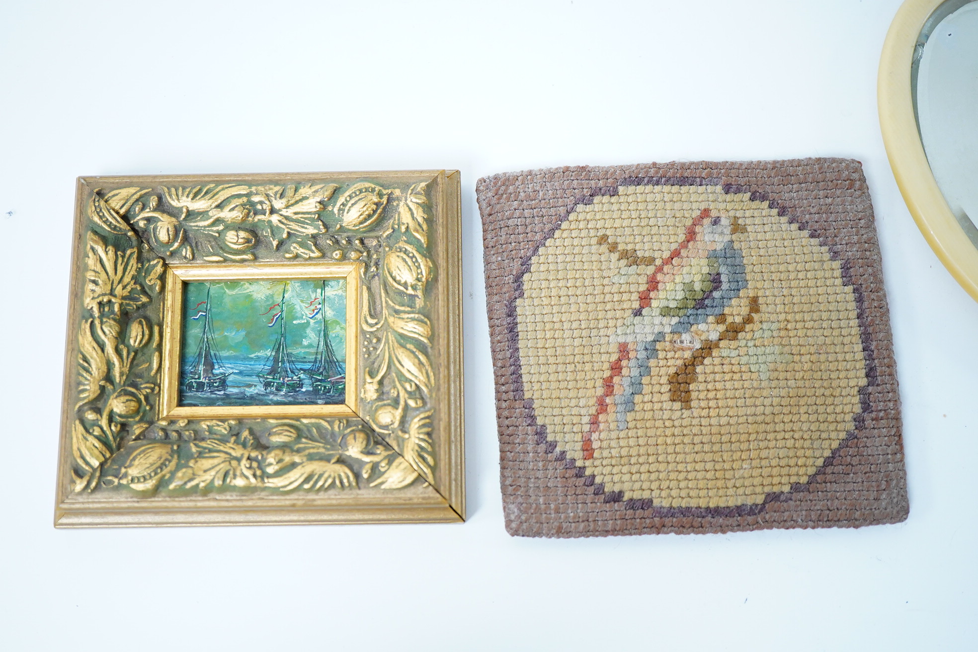 A small group of various collectables including an Edwardian oil on canvas board, study of a dog, a 19th century woolwork, cast iron bottle opener in the form of a parrot and an Art Deco bookend surmounted with a cat